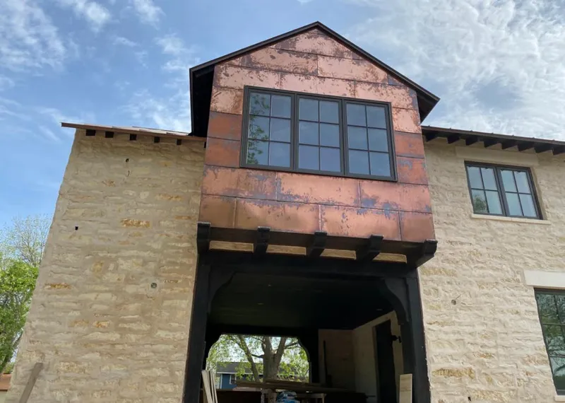 Copper metal panel facade on a stone building for Skylight Installation in Ocean Pointe